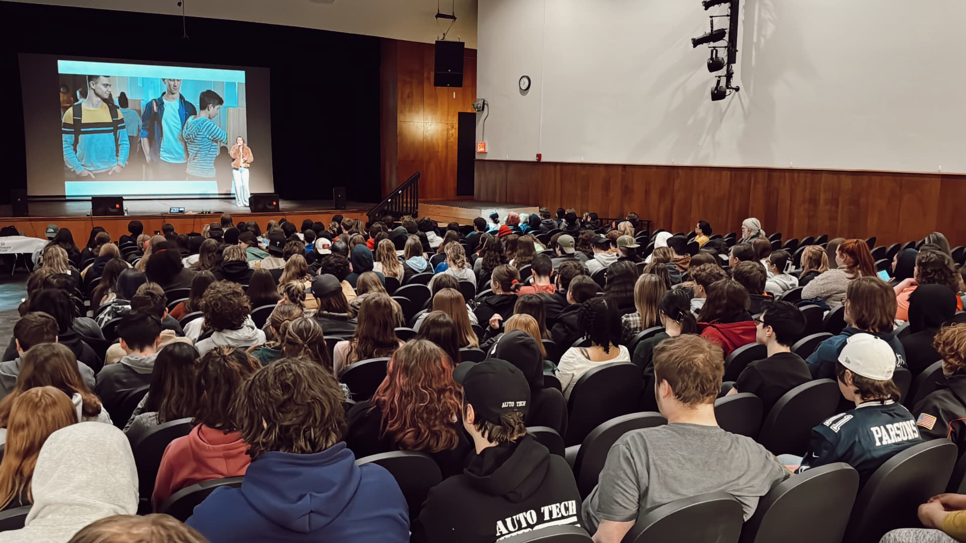 A packed school auditorium of students watching Rosevelt perform