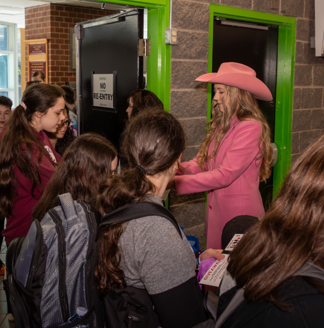 Students gathering around Rosevelt in a school hallway after an assembly