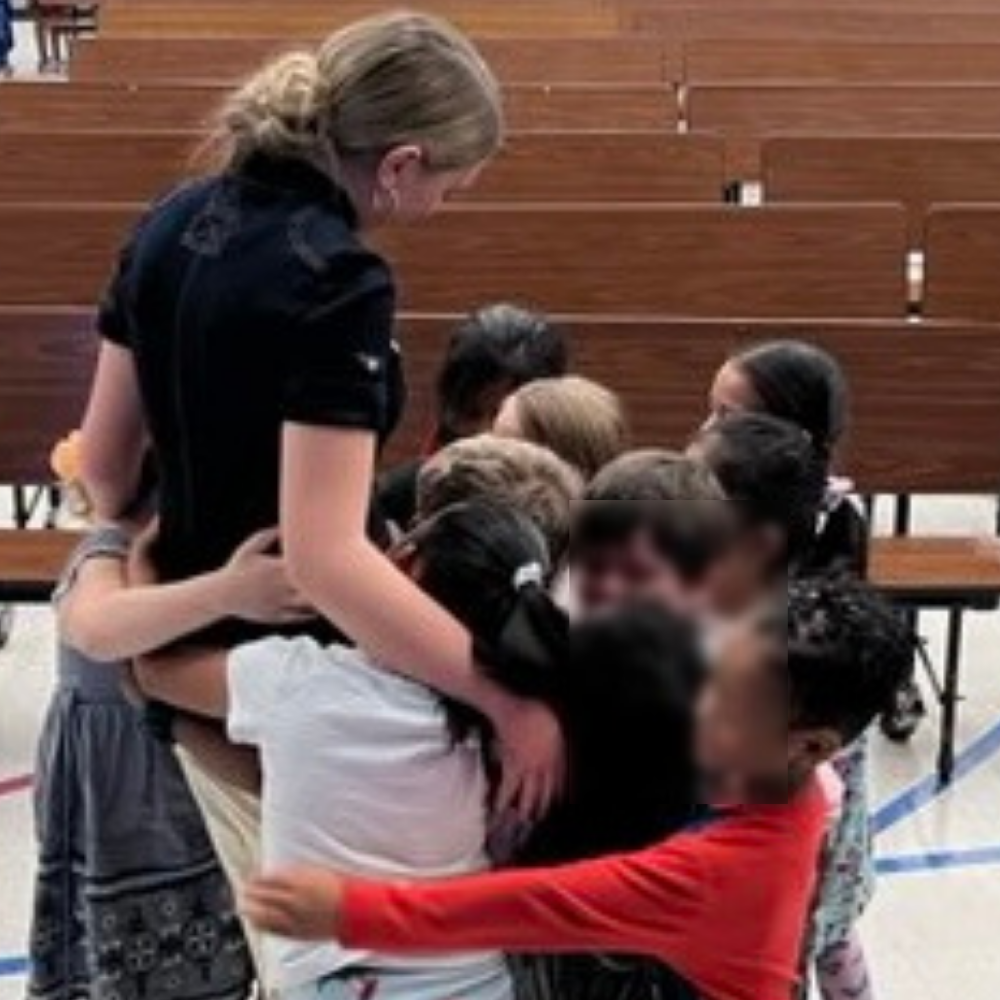 Children hugging after an assembly